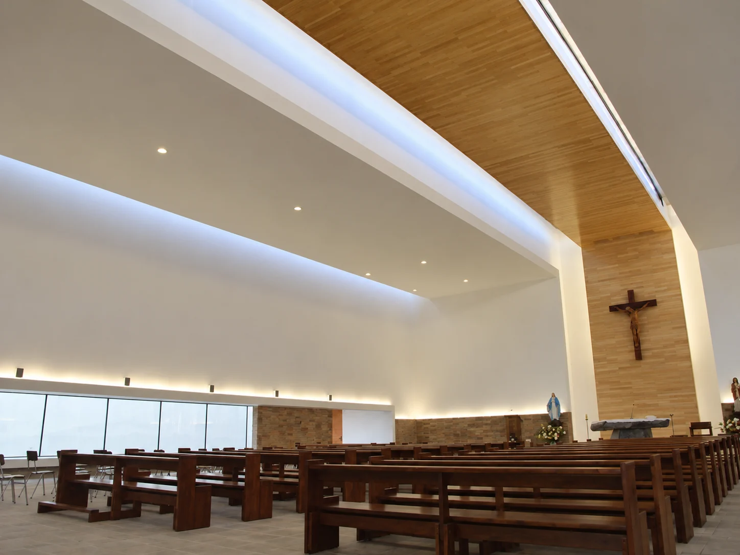 La luz natural entra por el lucernario y acompaña al crucifijo sobre el altar